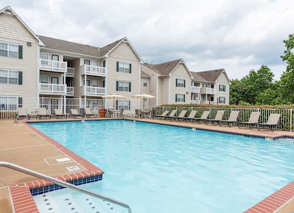 A large swimming pool in front of apartment buildings.