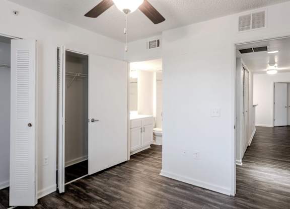 a bedroom with white walls and a ceiling fan