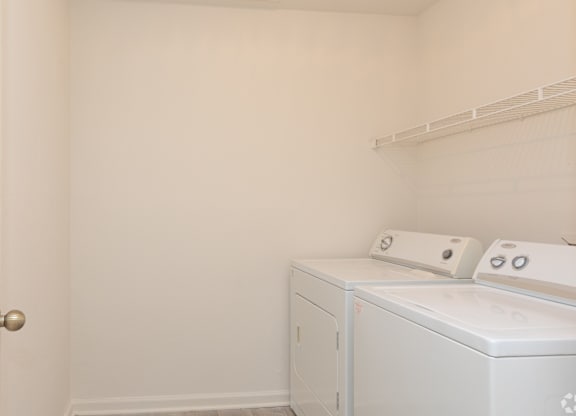 A white laundry room with a washer and dryer.