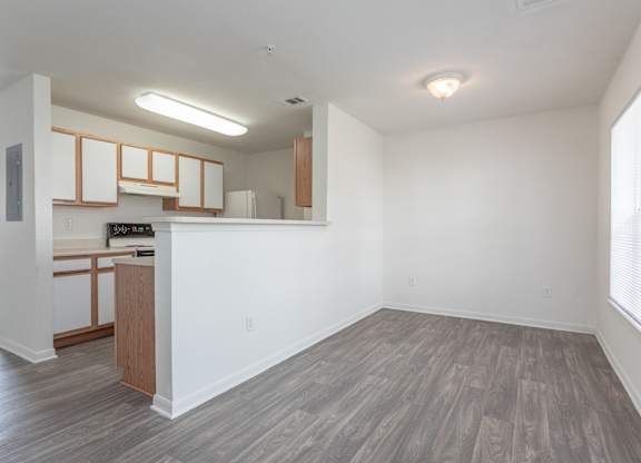 A kitchen with white walls and wooden floors.