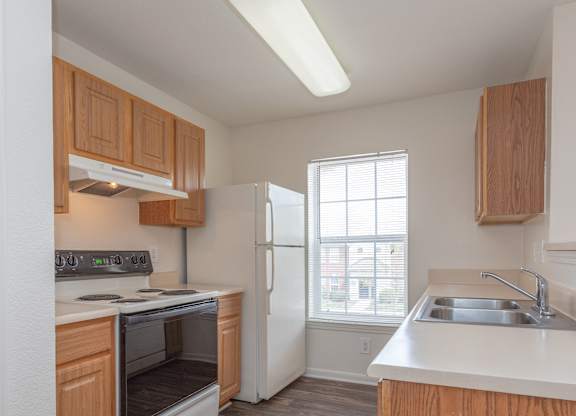 A kitchen with wooden cabinets and a white refrigerator.