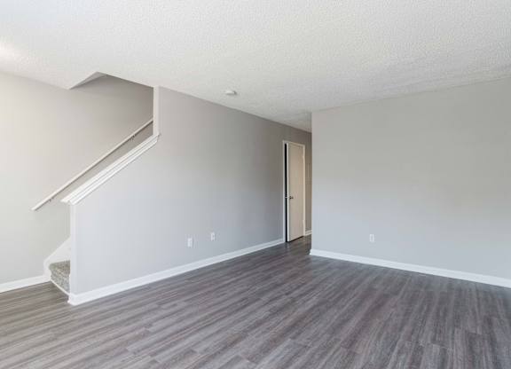 A room with a wooden floor and a staircase leading to the upper floor.at Jamestown Pointe Apartments, South Carolina, 29607