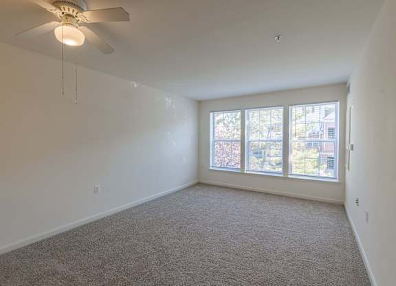 A room with a ceiling fan and carpeted floor.at Kendrick Court Senior Apartments, Herndon Virginia