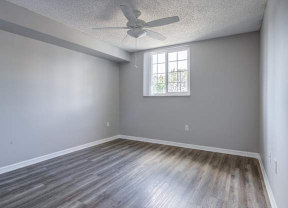 A room with a ceiling fan and a window.