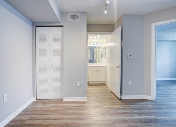 A room with a white door and a wooden floor.