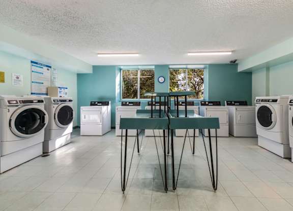 a laundry room with washing machines and a table in the middle of the room