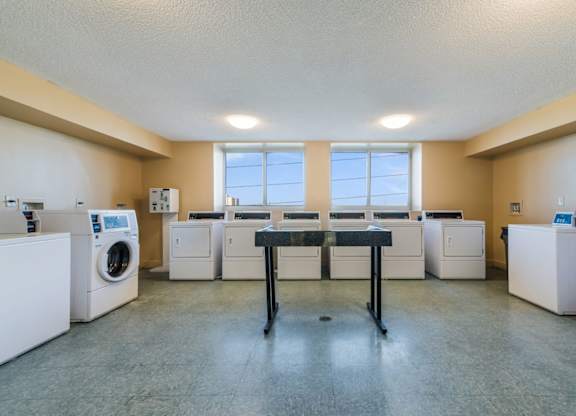 a laundry room with washing machines and a table in the middle of the room