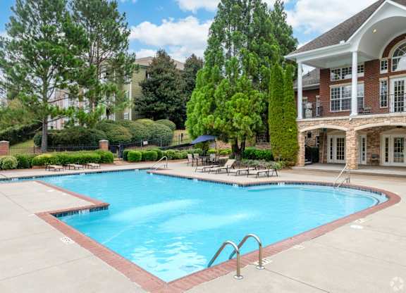 a large swimming pool in front of a building with a resort style pool at Magnolia Lake Apartments, Carrollton, Georgia
