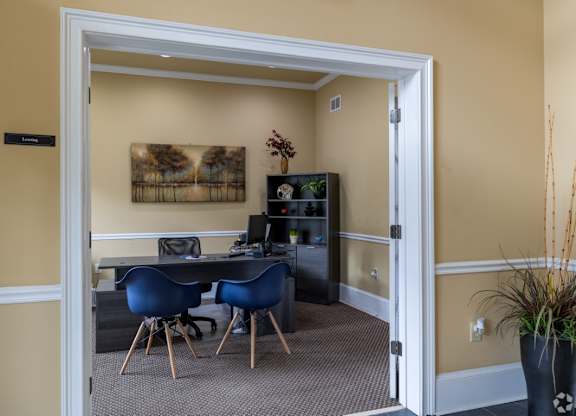 a room with a desk and chairs and a doorway at Magnolia Lake Apartments, Carrollton, GA