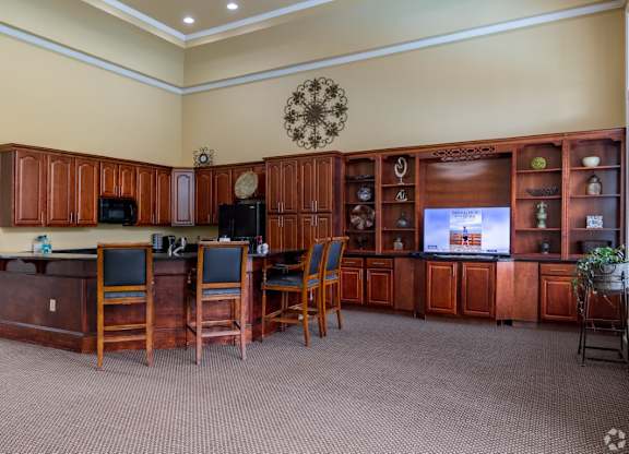 a break room with a table and chairs and a television at Magnolia Lake Apartments, Carrollton, GA, 30117