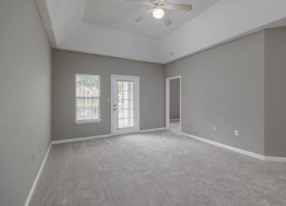 an empty living room with grey walls and a ceiling fan at Magnolia Lake Apartments, Carrollton, Georgia