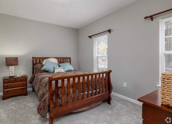 a bedroom with a bed and two windows at Magnolia Lake Apartments, Georgia
