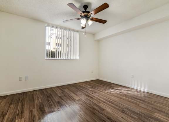 a bedroom with hardwood flooring and a ceiling fan