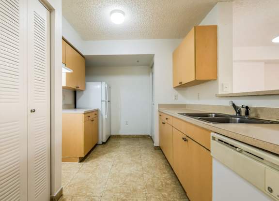 a kitchen with a white refrigerator freezer next to a stove top oven