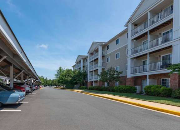 A parking lot with cars parked and apartment buildings in the background.