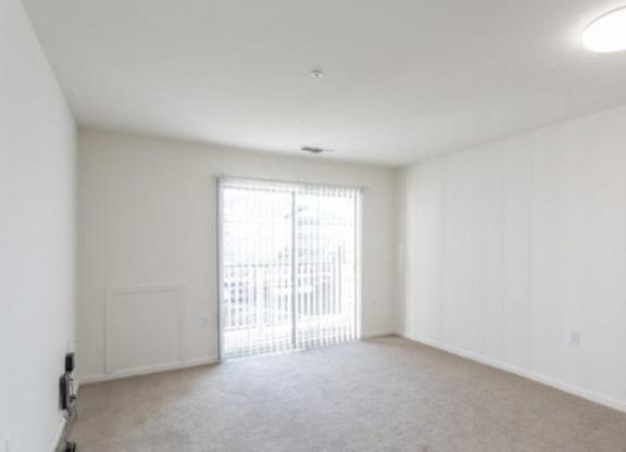 A large, empty room with a sliding glass door.
