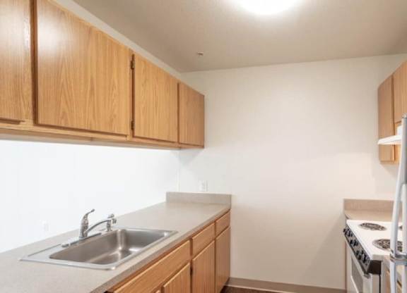 A kitchen with wooden cabinets and a white refrigerator.
