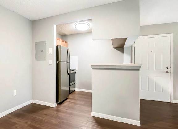 A kitchen with a refrigerator and a counter.