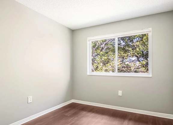 A room with a framed picture of a tree on the wall.