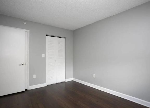 A room with a white door and a white closet.