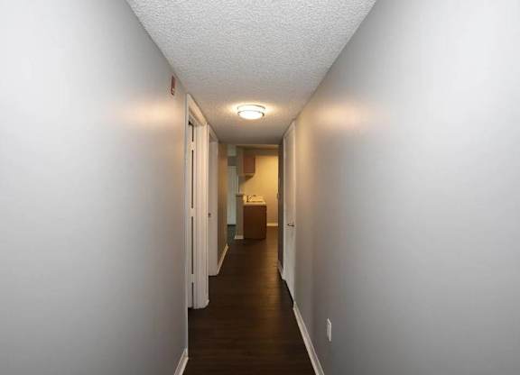 A long hallway with doors on both sides and a light on the ceiling.