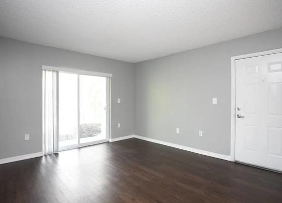 A room with a white door and a sliding glass door.