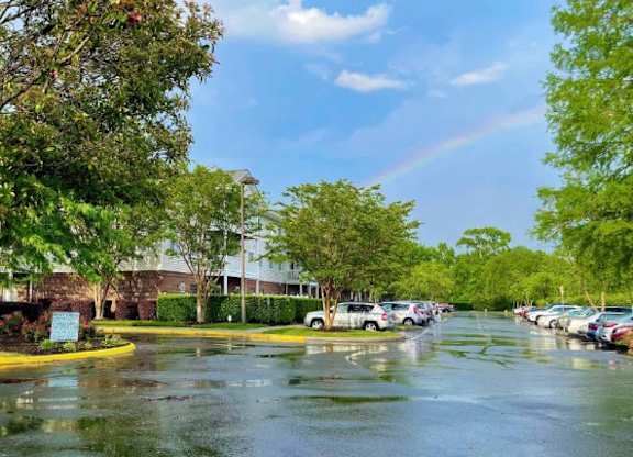 a rainy street with cars parked in a parking lot at Greenbrier Seniors Apartments, Chesapeake, VA 23320  
