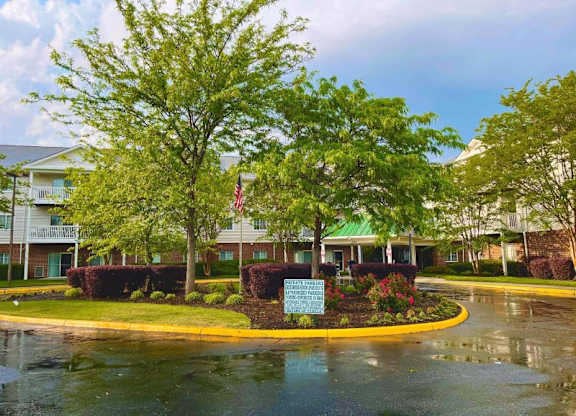 a roundabout with trees and a sign in front of a building at Greenbrier Seniors Apartments, Chesapeake, 23320  