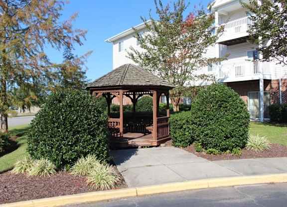 a gazebo in a yard in front of a house at Greenbrier Seniors Apartments, Chesapeake, 23320  