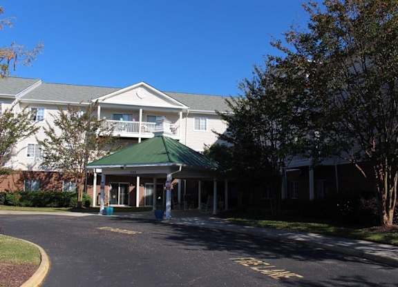 a building with a green roof on the side of a street at Greenbrier Seniors Apartments, Virginia  