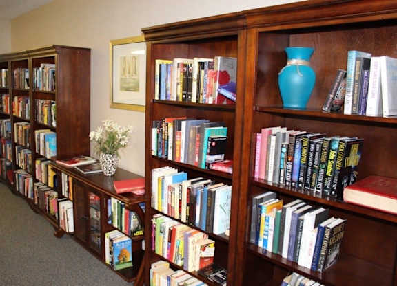 a book shelf filled with lots of books at Greenbrier Seniors Apartments, Chesapeake, VA 23320  