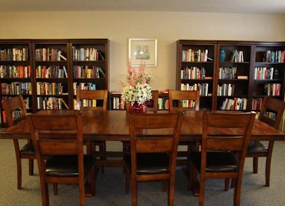 a library with a wooden table and chairs at Greenbrier Seniors Apartments, Chesapeake, 23320  