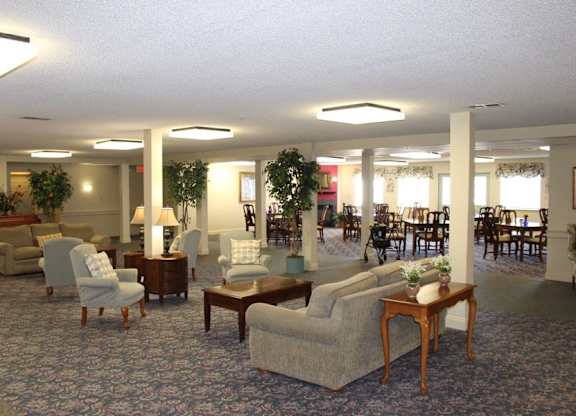 a living room with couches and chairs and tables at Greenbrier Seniors Apartments, Chesapeake 