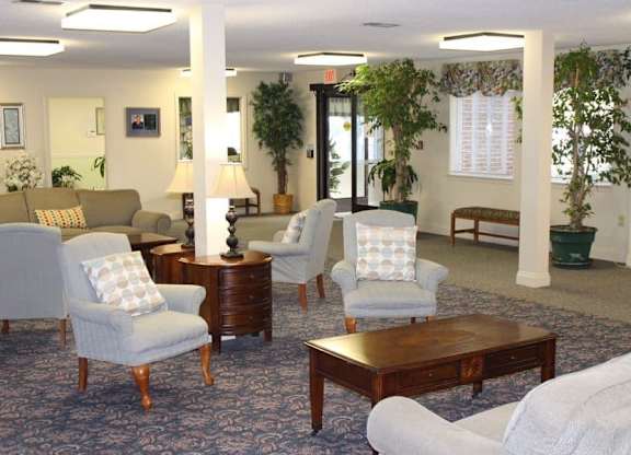 a living room with couches and chairs and a table at Greenbrier Seniors Apartments, Virginia  