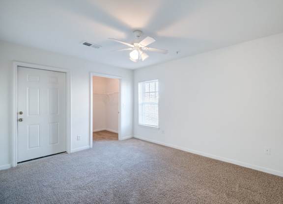 A room with a ceiling fan and carpeted floor at The Regency Apartment Homes/Broad Pointe, Manassas