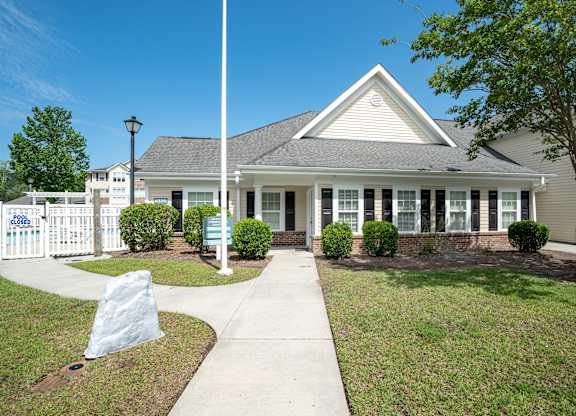 a house with a flagpole in front of it at Palms on Ashley River Apartments, Ladson