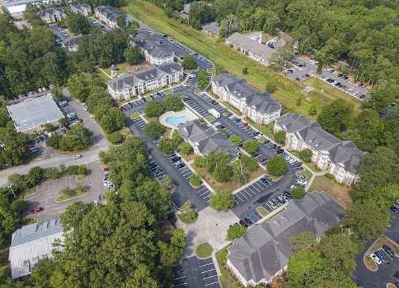 arial view of a neighborhood with houses and a swimming pool at Palms on Ashley River Apartments, Ladson, SC