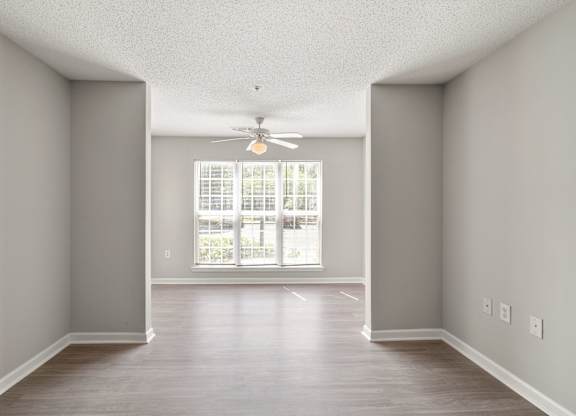 an empty living room with a ceiling fan at Palms on Ashley River Apartments, Ladson, South Carolina