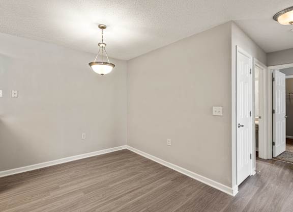 a bedroom with hardwood floors and grey walls at Palms on Ashley River Apartments, Ladson