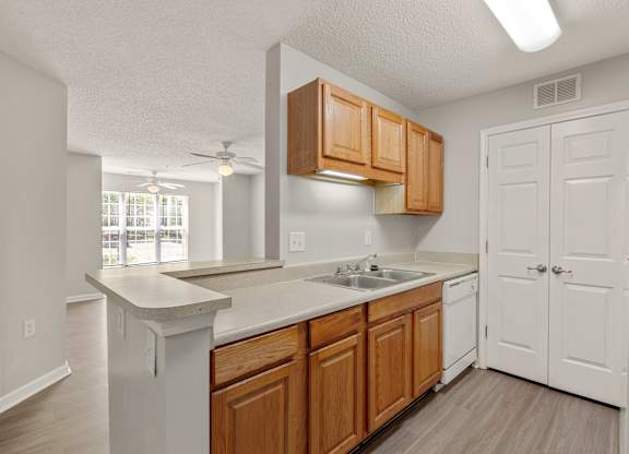 a kitchen with white appliances and wooden cabinets at Palms on Ashley River Apartments, Ladson, 29456