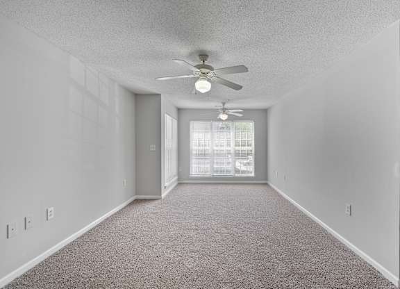 an empty room with a ceiling fan and a window at Palms on Ashley River Apartments, Ladson, 29456
