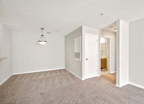 a living room with a carpeted floor and a doorway into a bathroom at Palms on Ashley River Apartments, Ladson, SC, 29456