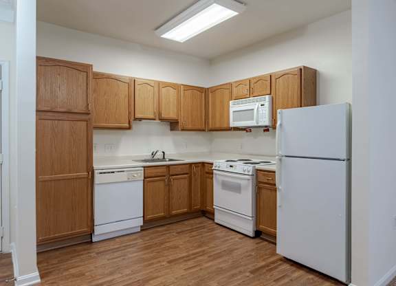 A kitchen with wooden cabinets and white appliances.