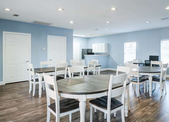 A dining room with a round table and chairs.