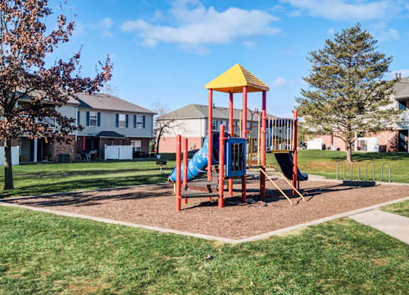A playground with a yellow and red structure and a blue slide.
