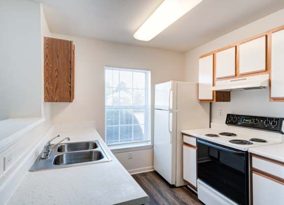 A kitchen with a black oven and white countertops.