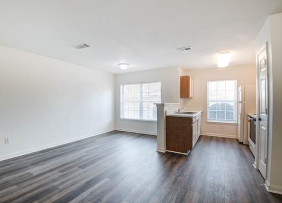 A kitchen area with a refrigerator, sink, and cabinets.