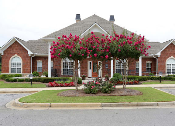 a house with a large flowering tree in front of it at Magnolia Lake Apartments, Carrollton, GA