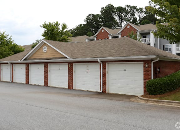 a garage with white doors in front of a house at Magnolia Lake Apartments, Carrollton, Georgia