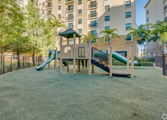 A playground with a green slide and a wooden structure.